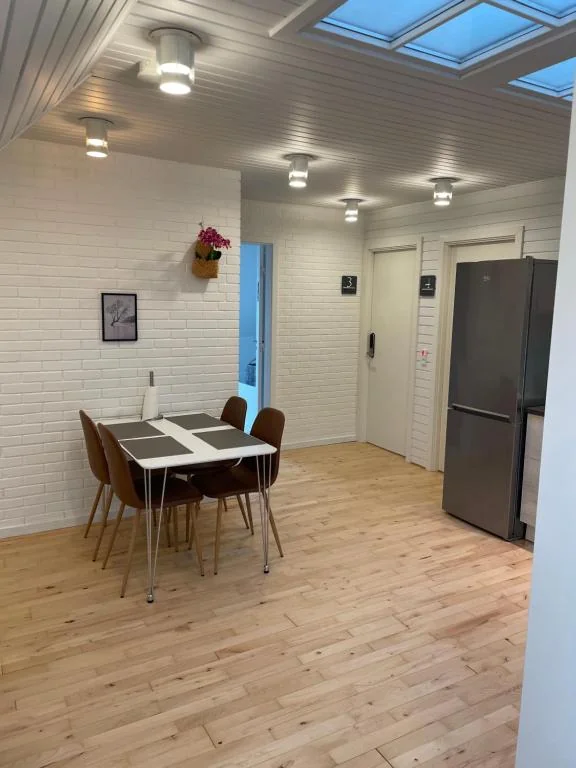 Spisebord i fællesrummet med køleskab i baggrunden