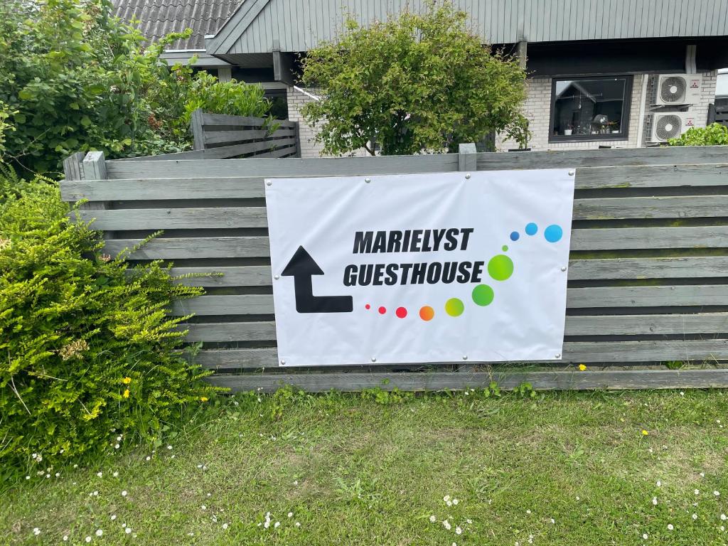 Haven med plæne, hegnet og Marielyst Guesthouse-flaget