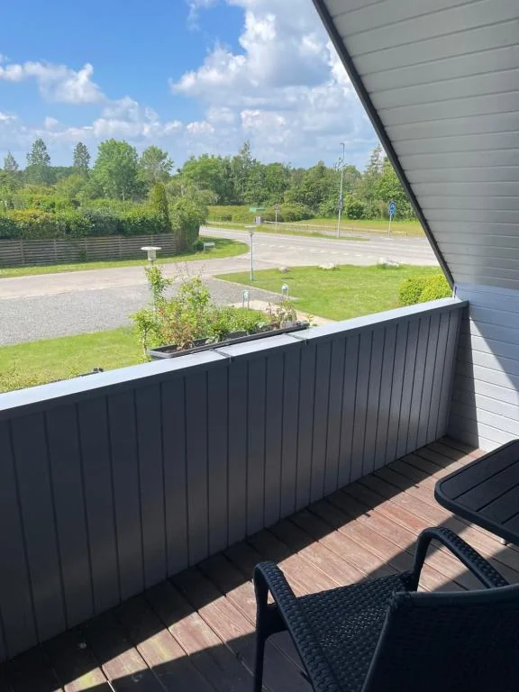 Balkon med udsigt over træer og vej