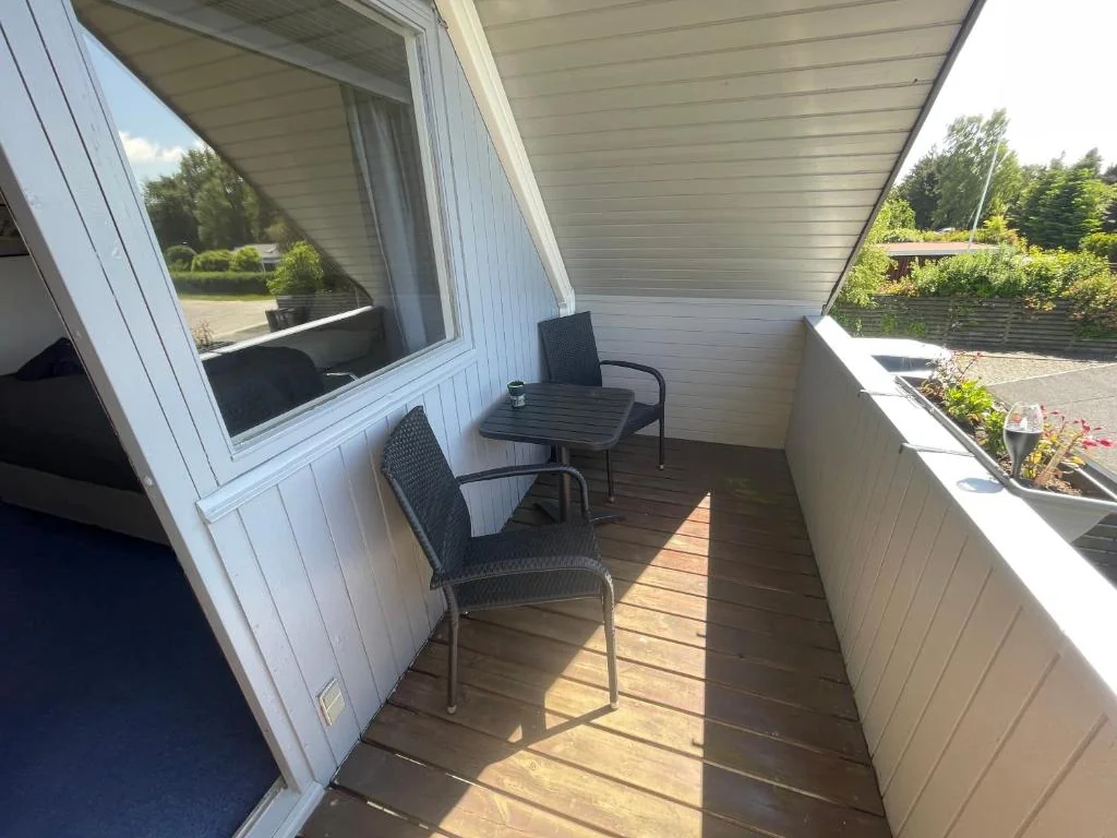 Balkon med havestole og bord under skråt tag