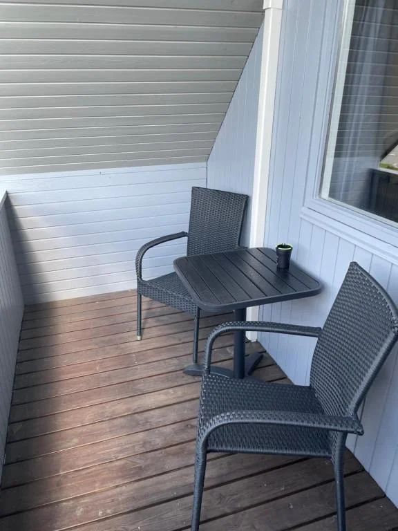 Balkon med to havestole og et lille bord